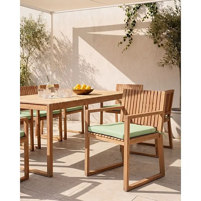 Beliani Gartenstuhl-Set SASSARI PREMIUM - 4 Stk., zertifiziertes Akazienholz, Braun, B x T x H: 54 x 59 x 80 cm - Teakholz-Gartenessgruppe mit Lamellentisch und Stühlen, hellgrünen Kissen, auf einer sonnigen Terrasse.