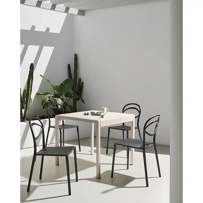 4er-Set Gartenstuhl COVOLO in Schwarz -  - Heller quadratischer Terrassentisch mit dunklen Stühlen in hellem Außenbereich mit Pflanzen. Spiel und Tasse auf dem Tisch.