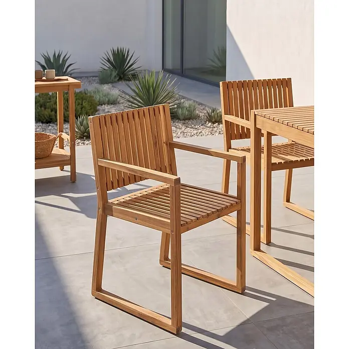 Beliani Gartenstuhl-Set SASSARI II - 2 Stk., zertifiziertes Akazienholz, Braun, B x T x H: 54 x 59 x 80 cm - Zwei Outdoor-Stühle und ein passender Tisch aus Holzlatten auf einer sonnigen Terrasse mit Pflanzen.