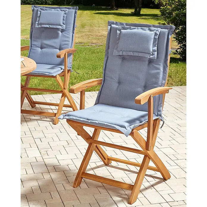 4er-Set Gartenstuhl MAUI II in Braun/Blau -  - Gartensessel aus Holz mit hellblauen Polstern und Kopfstütze auf einer gepflasterten Terrasse. Ein zweiter Stuhl ist teilweise sichtbar.