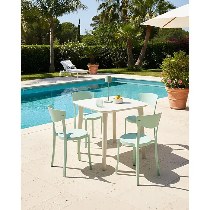 4er-Set Esszimmerstuhl VIESTE in Grün -  - Ein weißer Gartentisch mit vier mintgrünen Stühlen auf einer Terrasse am Pool.