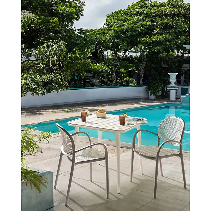 Beliani Gartenstuhl-Set POVOLETTO - 2 Stk., Polypropylen, Stapelbar, Braun, B x T x H: 50 x 50 x 85 cm - Helles beiges Gartentisch mit zwei hellgrauen geflochtenen Stühlen am Pool, für Getränke gedeckt.