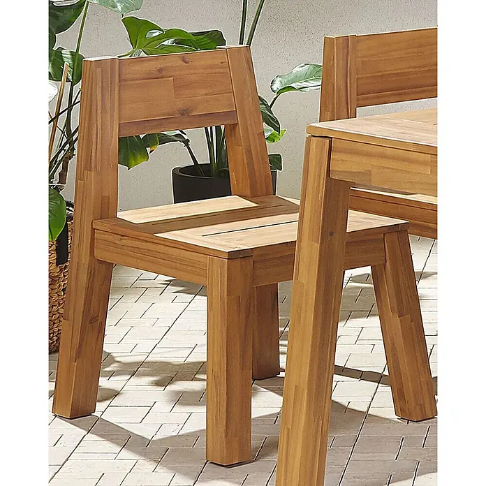 Beliani Gartenstuhl LIVORNO - 1 Stk., Akazienholz, Braun, B x T x H: 59 x 61 x 81 cm - Zwei Holzstühle und ein Teil eines passenden Tisches auf einer gefliesten Terrasse in natürlicher, grüner Umgebung.