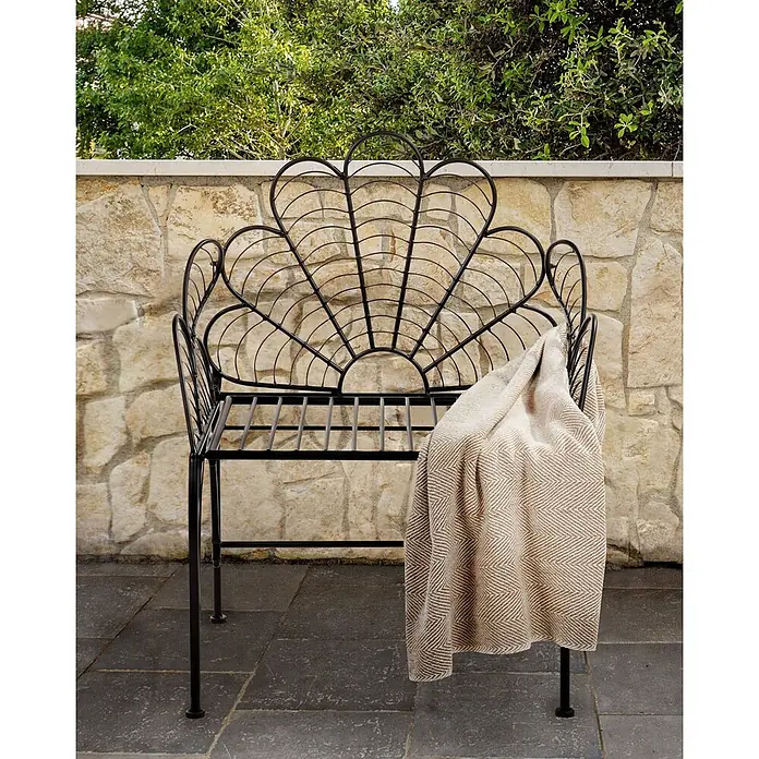 Beliani Gartenstuhl LIGURIA - 1 Stk., Eisen, Schwarz, B x T x H: 71 x 49 x 91 cm - Schwarze Metallgartenbank mit dekorativer Muschel-Rückenlehne und beiger Decke, auf einer Terrasse platziert.