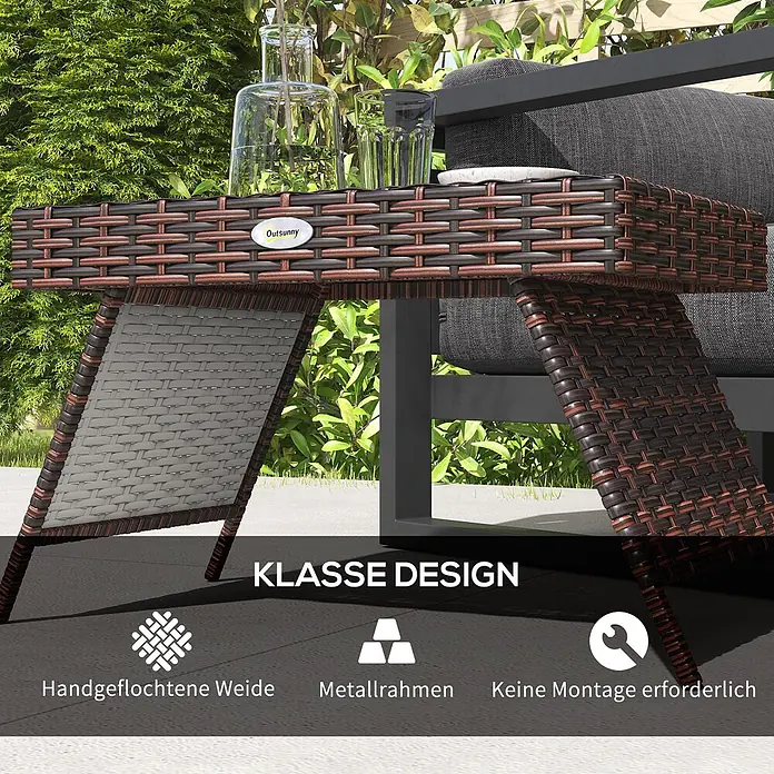 Furnicato Garten-Loungetisch - L x B x H: 60 x 41 x 41 cm, Braun - Brauner und schwarzer Rattan-Beistelltisch in C-Form mit Metallrahmen, neben einem Outdoor-Sofa, mit Getränken.