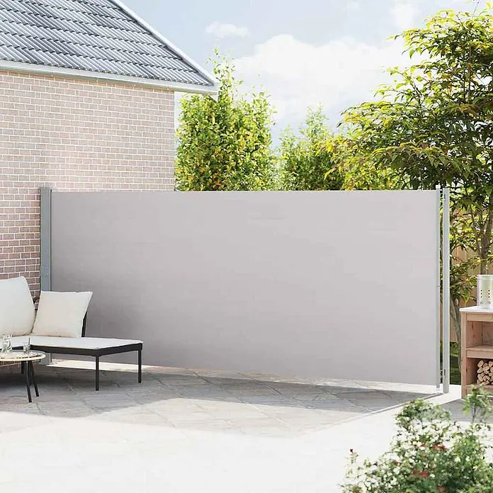 vidaXL Seitenmarkise Grau 600 x 180 cm Stoff -  - Graue ausziehbare Seitenmarkise auf einer Terrasse, die Sichtschutz neben einem Haus bietet.