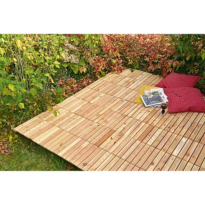 Klickfliese - Lärche, 30 x 30 x 3 cm, Braun, 1 Stk. - Ein einladender Außenbereich mit Holzfliesen, roten Kissen und einer Zeitschrift, ideal zum Entspannen im Garten.