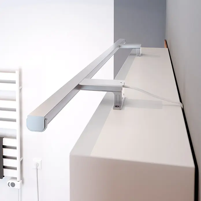 kalb LED Spiegelleuchte Lumenia 100cm 3000K Chrom 2in1 Montage -  - Lange, silberne LED-Leuchte über einem weißen Schrank montiert, zur Beleuchtung, mit sichtbarem Stromkabel.
