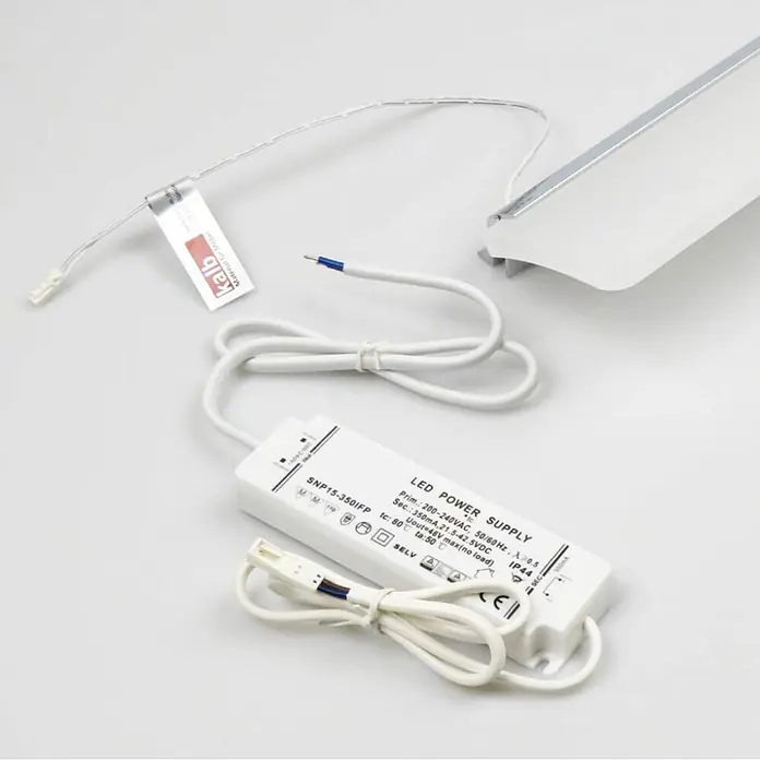 kalb LED Spiegelleuchte WhiteWave 60cm 3000K Chrom -  - Weißes LED-Netzteil mit Anschlusskabeln und einem Abschnitt einer LED-Lichtleiste.