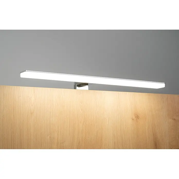 kalb LED Spiegelleuchte Selma 30cm 3000K Chrom 2in1 Montage -  - Lineare LED-Leuchte aus Chrom, die eine hellfarbige Holzplatte beleuchtet.