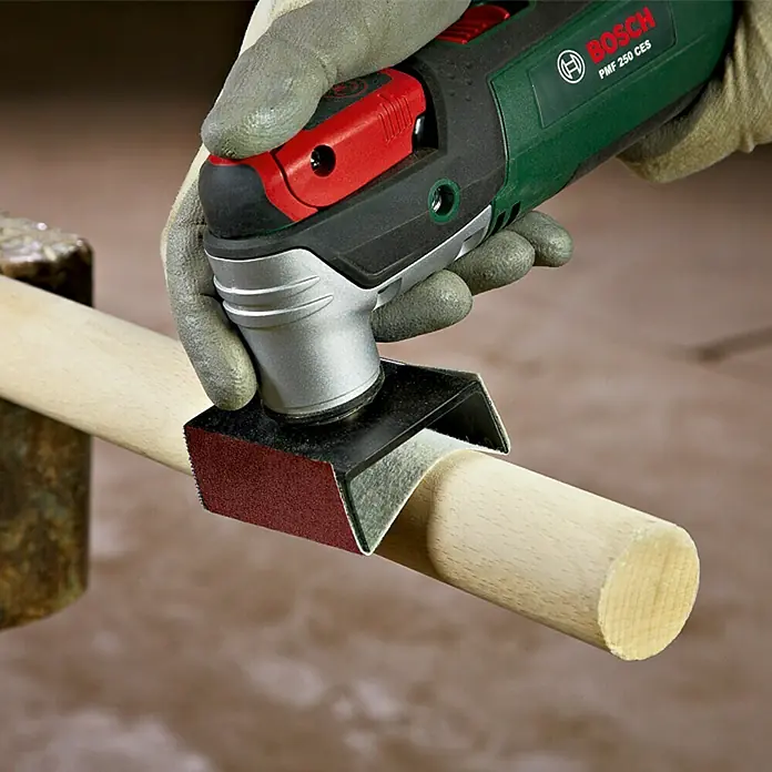 Bosch Taco lijador de perfiles AUZ 70 G - Apto para: Madera, Medidas papel abrasivo: 70 x 125 mm - Un primer plano de una multi-lijadora Bosch PME 250 CES que se usa para lijar una clavija de madera.
