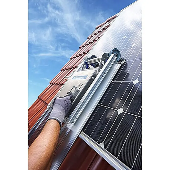 Mauderer Bavaria Wartungsleitern für Photovoltaik-Anlagen mit Plattform Leiterlänge 3,90m 14 Sprossen -  - Solarmodul-Aufzug wird auf einem Ziegeldach neben Solarmodulen von einer behandschuhten Hand bedient.