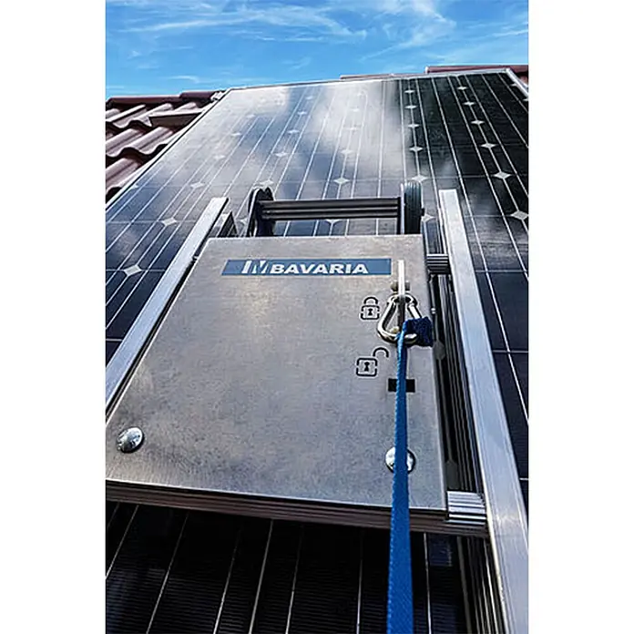 Mauderer Bavaria Wartungsleitern für Photovoltaik-Anlagen Leiterlänge 2,80m 10 Sprossen -  - Ein metallisches Gerät mit dem Logo „IN BAVARIA“, Rollen und blauem Gurt auf Solarmodulen auf einem Dach.