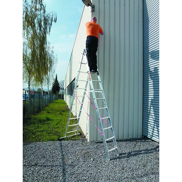 Euroline 207 Mehrzweckleiter 3x9 Sprossen -  - Silberne Mehrzweckleiter in A-Position, von einer Person für Arbeiten an einer Gebäudewand im Freien genutzt.