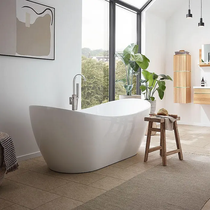 Home Deluxe Freistehende Badewanne OVALO - Weiß - Elegante weiße freistehende Badewanne mit hohem Wasserhahn in einem modernen, lichtdurchfluteten Badezimmer.