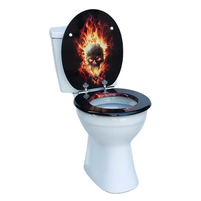 SAINOS WC-Sitz MDF WC-Sitz, Universal-O-Form, Absenkautomatik, Unten - MDF, Schwarz, Mit Absenkautomatik - Weißes WC mit schwarzem Deckel und Sitz, bedruckt mit einem flammenden Totenkopf. Deckel offen, passendes Design sichtbar.