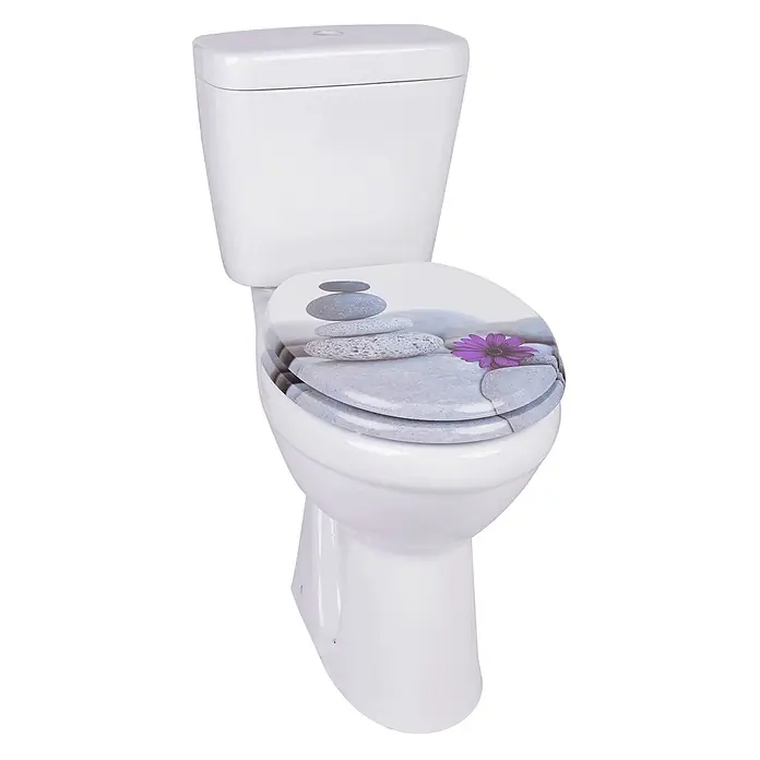 SAINOS WC-Sitz MDF WC-Sitz, Universal-O-Form, Absenkautomatik, Unten - MDF, Grau, Mit Absenkautomatik - Weißes Keramik-WC mit einem Zierdeckel, der gestapelte graue Steine und eine lila Blume zeigt.