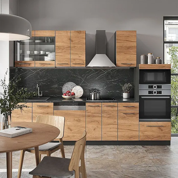 Küchenzeile Fame-Line 300 cm Goldkraft Eiche Art.-Nr. 42170 -  - Moderne Küche mit hellen Holzfronten, schwarzer Marmor-Arbeitsplatte und -Rückwand, mit Einbaugeräten und Essbereich.