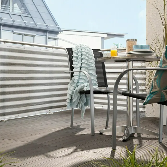 Gardol Balkonsichtschutz - Anthrazit/Weiß, 5 x 0,9 m - Balkon mit silbernem Tisch und Stühlen, dekoriert mit einer weichen Decke und Kissen, für eine gemütliche Atmosphäre im Freien.