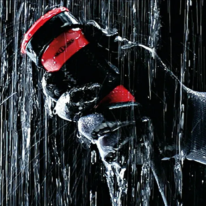 ABL Sursum Gummi-Schutzkontakt-Kupplung SCHUKOultra Pro - Rot/Schwarz, 250 V, IP54 - Hände in schwarzen Handschuhen halten eine Black Diamond Stirnlampe im Regen, die für Outdoor-Abenteuer geeignet ist.