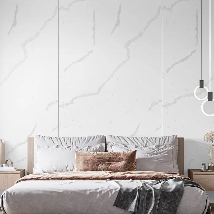 LOGOCLIC Wandpaneel Designwall - 265 x 123 cm, Statuario Bianco, Stone Polymer Composite (SPC) - Weiße, marmorierte Wandverkleidung hinter einem Bett in einem modernen Schlafzimmer.