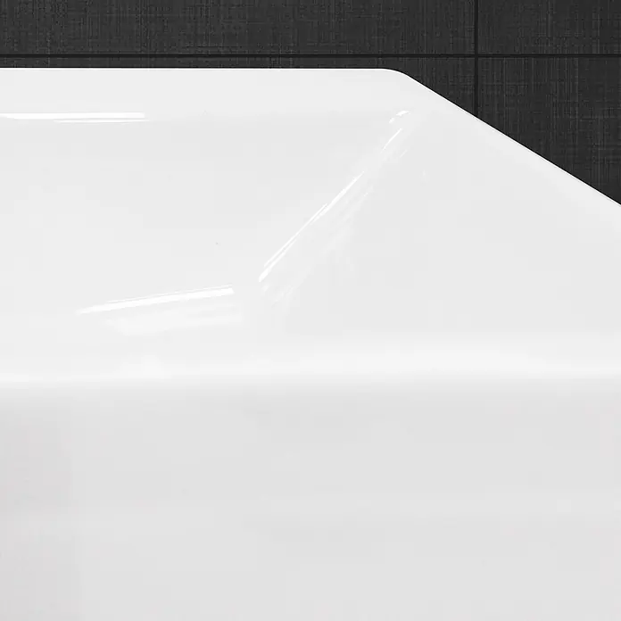 LuxeBath Waschbecken Keramik Waschtisch - 605x365x130 mm - Eckig -  - Weiße glänzende Oberfläche mit abgerundeter Ecke, mit Reflexionen vor einer dunklen strukturierten Wand.