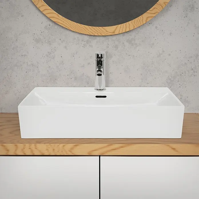 LuxeBath Waschbecken Keramik Waschtisch - 605x365x130 mm - Eckig -  - Ein modernes rechteckiges weißes Keramik-Waschbecken mit Chromarmatur auf einer hellen Holzplatte vor einer Betonwand mit rundem Spiegel.