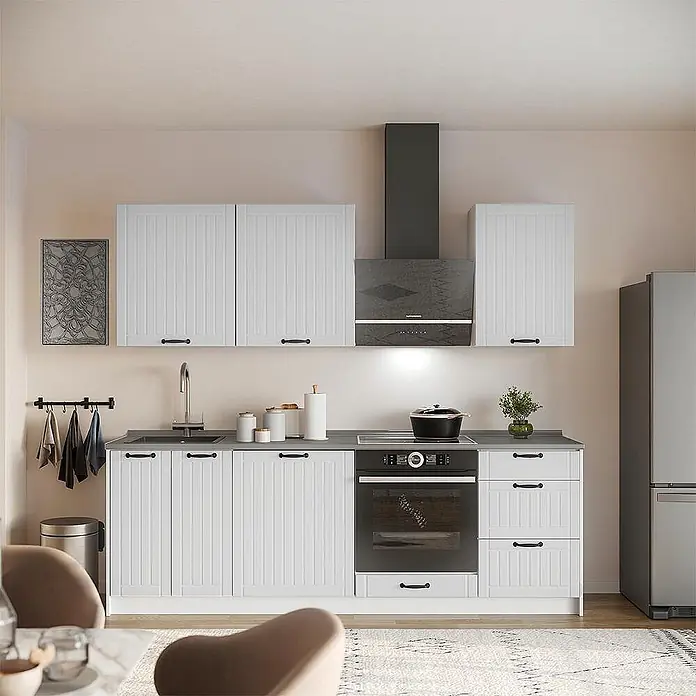 Vicco Küchenzeile - Breite: 230 cm, Weiß Landhaus, Ohne Elektrogeräte - Moderne Küche mit weißen gerillten Schränken, dunkler Arbeitsplatte, integriertem Ofen und schwarzer Dunstabzugshaube.
