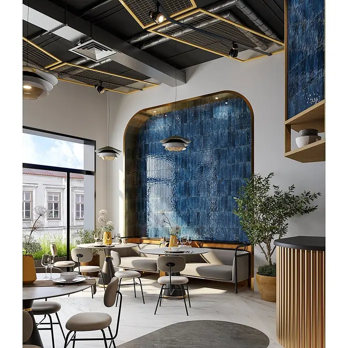 Wandfliese JULIET BLEU – 7.5 x 30 cm, Zellige-Optik, Brillant -  - Modernes Restaurant-Interieur mit blauer Fliesenakzentwand, Industriedecke und modernen Sitzgelegenheiten.