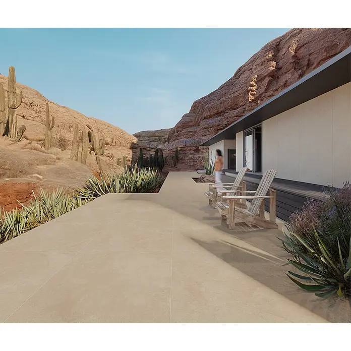 Feinsteinzeugfliese BURGOGNA STONE – 120 x 120 cm, Steinoptik, Mat -  - Große, sandfarbene Outdoor-Fliesen bilden eine geräumige Terrasse vor einem modernen Wüstenhaus.