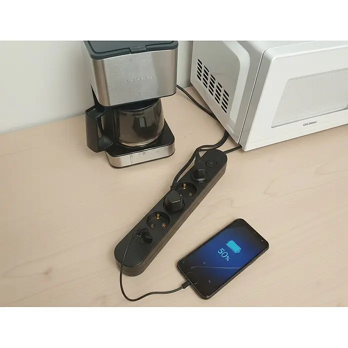 Base de enchufe múltiple Small Device Essential 4 - Negro, Longitud del cable: 1,5 m, Con interruptor - Regleta negra conectada a una cafetera, un microondas y un smartphone cargándose.