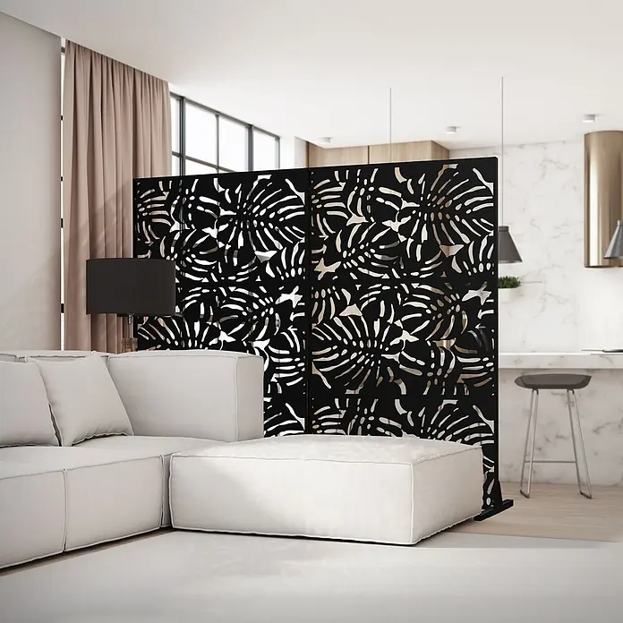 ML-Design Sichtschutzelement Roma - B x H: 120 x 183 cm, Stahl, Schwarz - Schwarzer Raumteiler mit Monstera-Blattmuster, trennt ein hellgraues Sofa von einer Küchentheke in einem modernen Interieur.