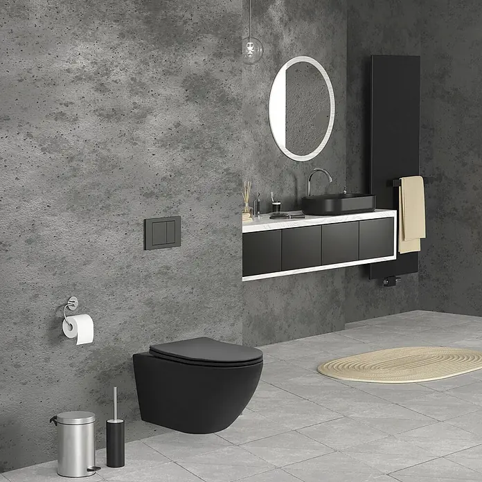 LuxeBath Wand-WC lang Schwarz matt Duroplast Tiefspüler - Spülrandlos, Spülform: Tief, WC Abgang: Waagerecht, Schwarz - Modernes Bad mit schwarzer Wandtoilette, passendem schwarzem Waschtisch und Handtuchwärmer, vor Betonwänden und Fliesenboden.