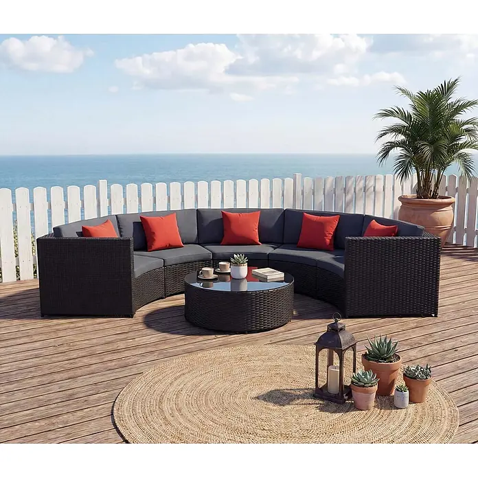 Mendler Loungemöbel-Set HWC-E17 - 6 -tlg., Polyrattan, Schwarz, Polster dunkelgrau, Kissen terracotta, Schwarz, dunkelgrau - Dunkles geflochtenes, geschwungenes Outdoor-Sofa mit grauen Kissen, roten Polstern und passendem Couchtisch, auf einer Terrasse.