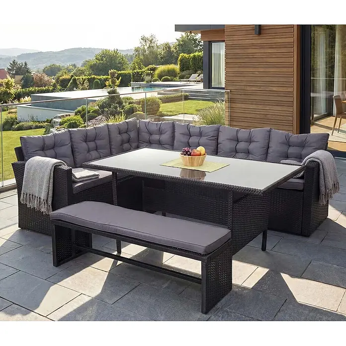 Mendler Loungemöbel-Set HWC-A29 - 3 -tlg., Polyrattan, Kissen dunkelgrau, mit Bank, Schwarz, dunkelgrau - Schwarze Rattan-Garten-Essecke mit grauen Kissen, Tisch und Bank auf einer Terrasse.