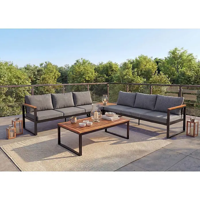 Mendler Garten-Garnitur HWC-L26 Aluminium - dunkelgrau -  - Modernes Outdoor-Terrassenset mit zwei grauen Sofas, einem Holzkaffeetisch und Laternen auf einem Teppich, auf einem sonnigen Balkon mit Baumblick.
