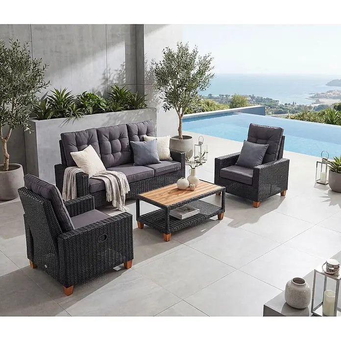 Mendler Loungemöbel-Set HWC-G28 - 4 -tlg., Polyrattan, Anthrazit, Kissen grau, Anthrazit, Kissen grau - Outdoor-Loungeset aus dunklem Rattan mit grauen Kissen, bestehend aus Sofa, zwei Sesseln und Couchtisch auf einer Terrasse.
