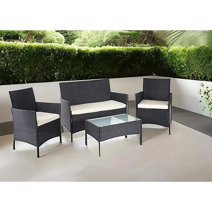 Mendler Poly-Rattan Garten-Garnitur HWC-D82 - schwarz mit Kissen Creme -  - Vierteiliges schwarzes Rattan-Gartenmöbelset mit cremefarbenen Kissen, bestehend aus Sofa, zwei Sesseln und Couchtisch, auf einer hellen Terrasse.