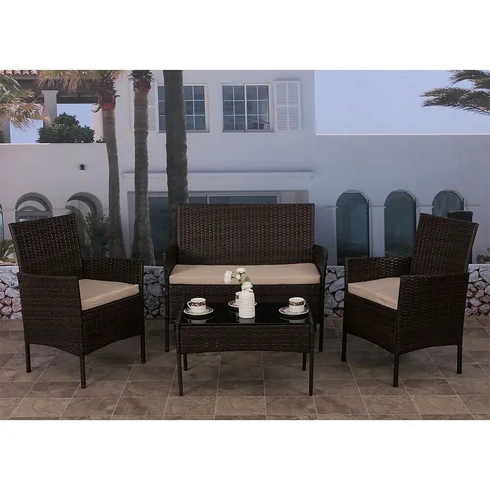 Mendler Loungemöbel-Set HWC-N98 - 4 -tlg., Polyrattan, Braun, Kissen creme, Braun, creme - Ein 4-teiliges dunkelbraunes Rattan-Gartenmöbelset mit beigen Kissen: zwei Sessel, ein Zweiersofa und ein Couchtisch mit Glasplatte auf einer Terrasse.