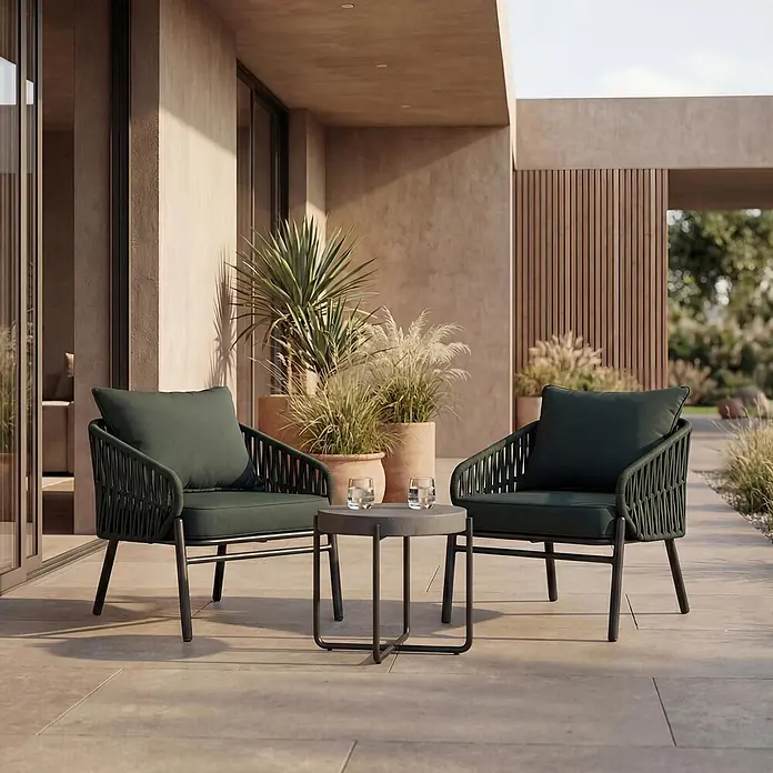 Mendler Gartensessel HWC-P90 - 1 Stk., Metall, Grün, B x T x H: 64 x 70 x 67 cm - Zwei dunkelgrüne geflochtene Outdoor-Sessel und ein kleiner runder grauer Tisch auf einer modernen Terrasse.