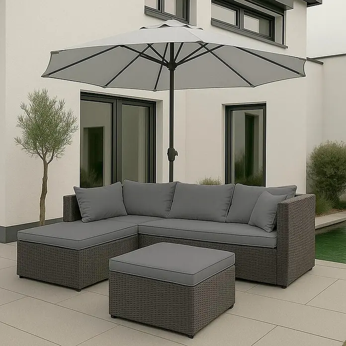 Mendler Poly-Rattan Garnitur HWC-O46 - grau Polster hellgrau -  - Graues Rattan-L-Sofa mit grauen Kissen und passendem Hocker auf einer Terrasse unter einem großen grauen Sonnenschirm.