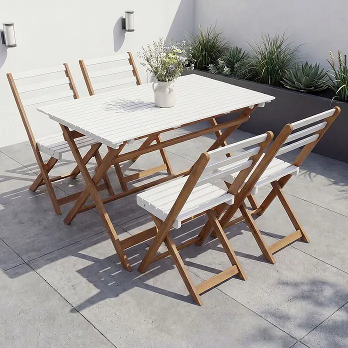 Mendler Garnitur HWC-P72 Akazie Holz klappbar - Natur-weiß -  - Weißes Lamellen-Gartenset aus Holz mit Tisch und vier Stühlen auf einer Terrasse.