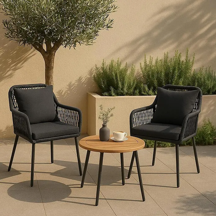 Mendler 2x Gartenstuhl HWC-O12 Rückenpolster - anthrazit, Bezug dunkelgrau -  - Outdoor-Sitzgruppe mit zwei dunkelgrauen Geflechtsesseln und einem runden Holztisch auf einer gefliesten Terrasse.