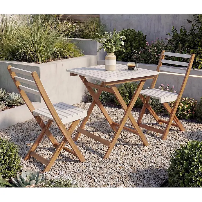 Mendler Garnitur HWC-P71 Akazie Holz klappbar - Natur-weiß -  - Hölzernes Bistro-Set mit weißer Lattenplatte und zwei Stühlen in einer Gartenszene.