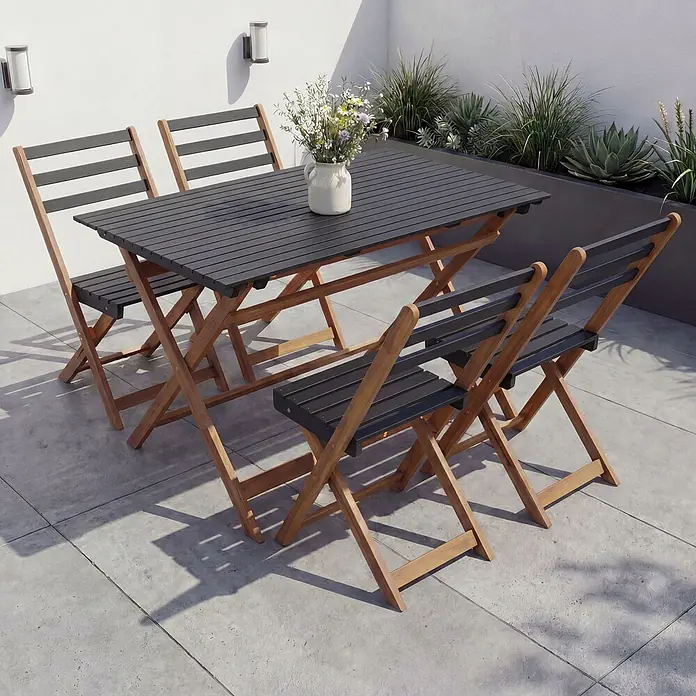 Mendler Garnitur HWC-P72 Akazie Holz klappbar - Natur-schwarz -  - Klappbares Outdoor-Essgruppe aus Naturholz mit dunkelgrauer Lattenplatte und vier Stühlen auf einer Terrasse.