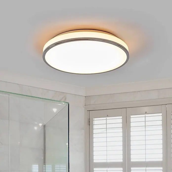 Lindby LED Deckenlampe in weiß, chrom, Deckenleuchte rund -  - Runde LED-Deckenleuchte mit silbernem Rand, die ein modernes Badezimmer beleuchtet.