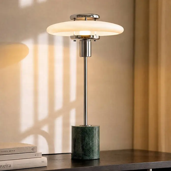Lindby Tischlampe in grün, Nachttischlampe -  - Moderne Tischlampe mit gestuftem Glasschirm, Chromschaft und grünem Marmorsockel auf dunklem Tisch.