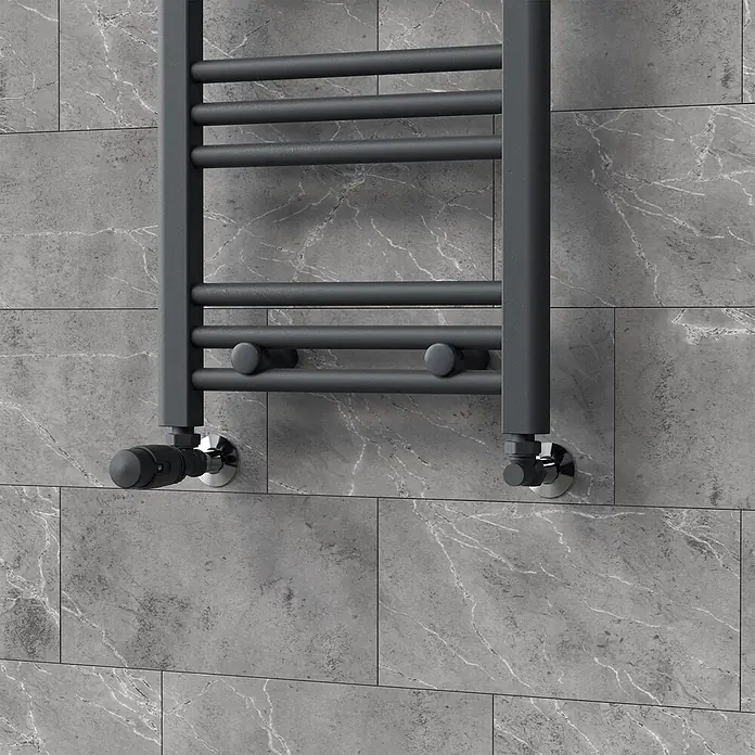 LuxeBath Heizkörperventil 1/2 Zoll, Heizungsventil für Heizkörper, Eckform -  - Dunkelgrauer Handtuchheizkörper mit horizontalen Stangen und integrierten Ventilen, an grauer Fliesenwand.