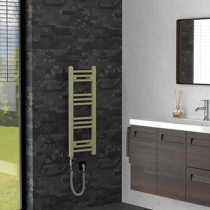 LuxeBath Badheizkörper Sahara Elektrisch 300 x 800 mm -  - Beiger elektrischer Handtuchwärmer an dunkel gefliester Badezimmerwand, mit angeschlossenem Netzkabel.