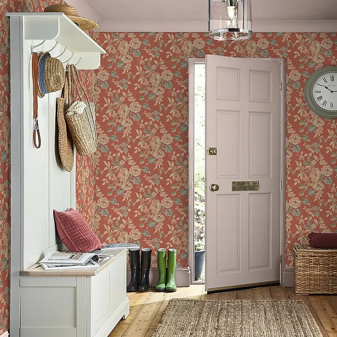 Vliestapete Hibiskusblüten 1000x52cm Laura Ashley -  - Florale Tapete in Terrakotta mit hellen Blüten und grünen Blättern, schmückt einen einladenden Eingangsbereich mit Garderobe und offener Tür.